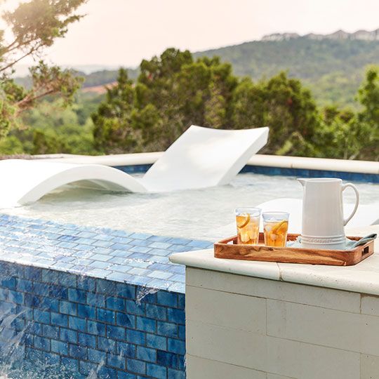 white pitcher set by a modern lounge chair near the pool