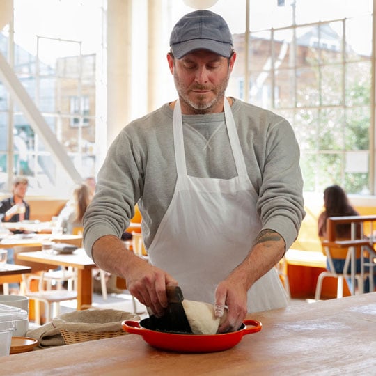 Chad Robertson works with dough in a Le Creuset bread oven