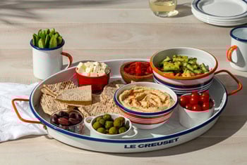 hummus, veggies and bread on an oval serving tray