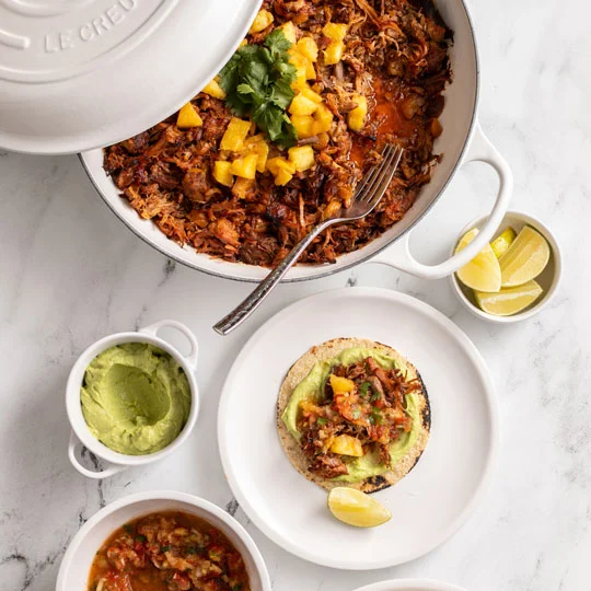 preparing a taco with braised pork and pineapple