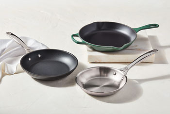 skillets made of different materials on a counter