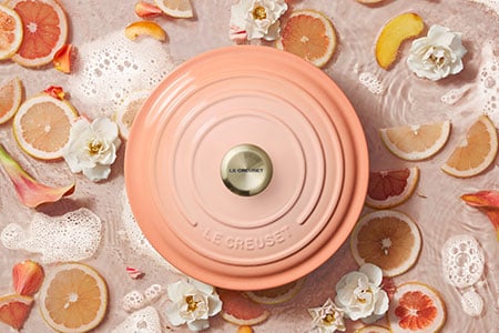 peche lid surrounded by fruit slices and flowers