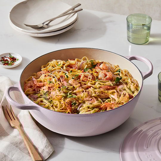 shrimp and pasta in a soft pink dutch oven