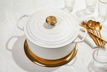 white dutch oven with a gold knob