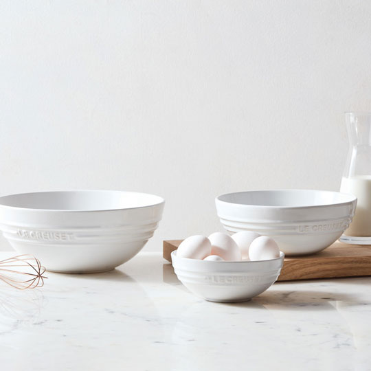 white bowls with eggs and a glass pitcher of milk