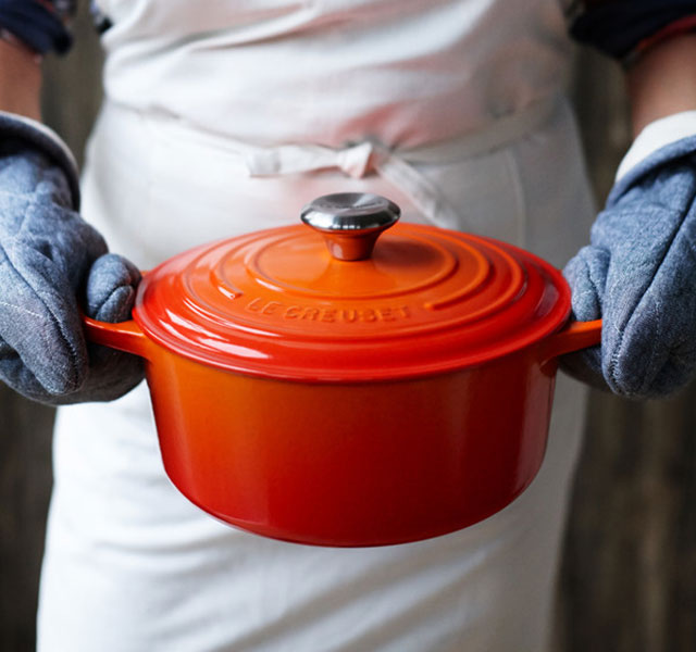 carrying a flame orange dutch oven with mitts