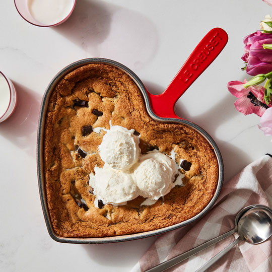 heart-shaped skillet filled with chocolate chip cookie