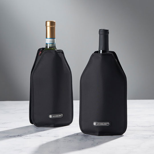 two bottles of wine in black insulated sleeves emblazoned with the Le Creuset logo