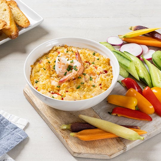 creamy dip topped with panko and shrimp surrounded by veggies
