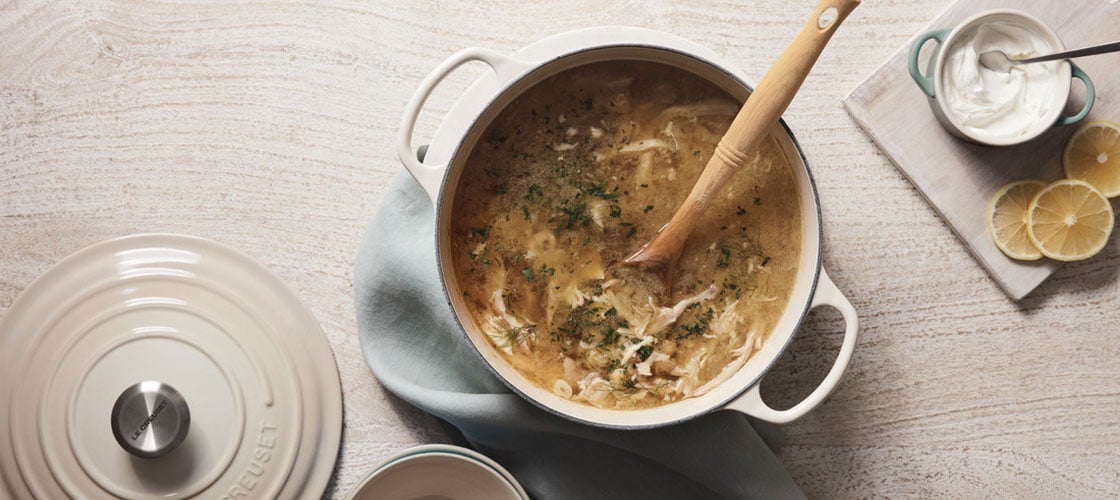 lemon chicken soup in a dutch oven with sour cream on the side